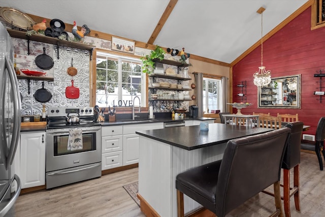 4695 Star Meadow Rd, Whitefish, MT 59937 - kitchen featuring appliances with stainless steel finishes, open shelves, vaulted ceiling, dark countertops, and wooden walls