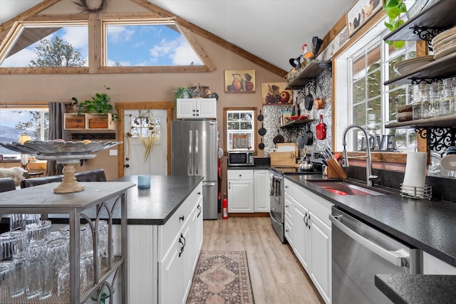 4695 Star Meadow Rd, Whitefish, MT 59937 - kitchen featuring appliances with stainless steel finishes, dark countertops, open shelves, light wood finished floors, and white cabinets