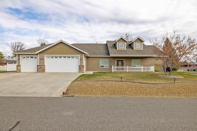 view of front of property featuring an attached garage, fence, a front yard, and concrete driveway