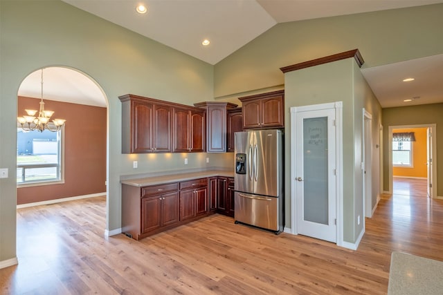 kitchen featuring stainless steel refrigerator with ice dispenser, light countertops, light wood-style floors, and a notable chandelier