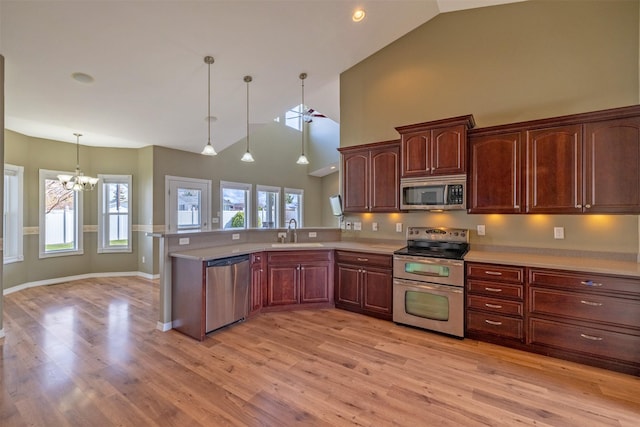 kitchen featuring light countertops, appliances with stainless steel finishes, a notable chandelier, and a sink
