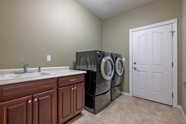 laundry area featuring cabinet space, washing machine and clothes dryer, baseboards, and a sink