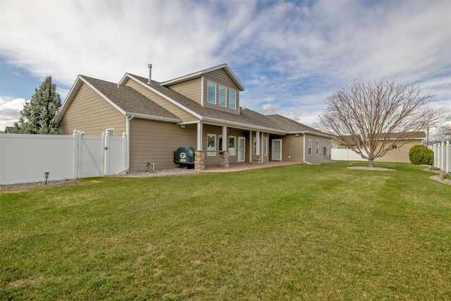 rear view of property with a lawn, a fenced backyard, a gate, and roof with shingles