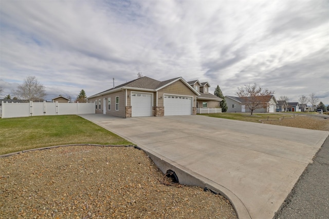 view of front facade with an attached garage, driveway, a front lawn, and fence
