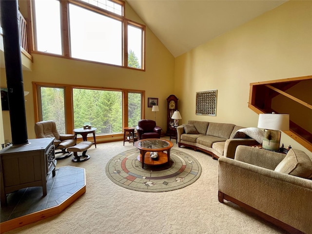 69 Fir Dr, Thompson Falls, MT 59873 - carpeted living area featuring high vaulted ceiling, a wood stove, and a healthy amount of sunlight