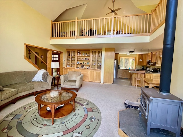 69 Fir Dr, Thompson Falls, MT 59873 - living area featuring high vaulted ceiling, a wood stove, light carpet, and a ceiling fan