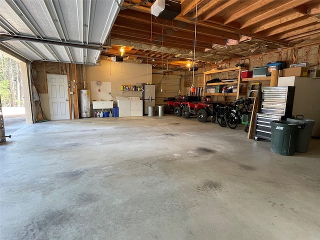 69 Fir Dr, Thompson Falls, MT 59873 - garage featuring freestanding refrigerator, a workshop area, gas water heater, washing machine and dryer, and a garage door opener