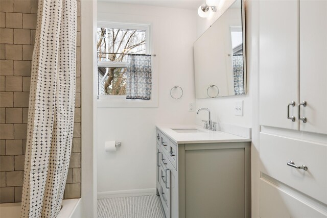bathroom featuring shower / bath combo, tile patterned flooring, vanity, and baseboards