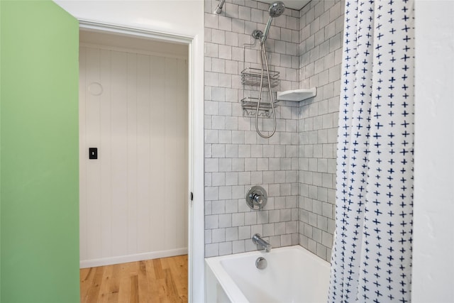 full bath with shower / tub combo with curtain, wood finished floors, and baseboards