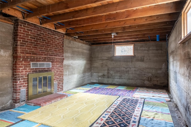 below grade area with a brick fireplace and visible vents