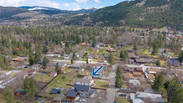 drone / aerial view with a wooded view, a mountain view, and a residential view
