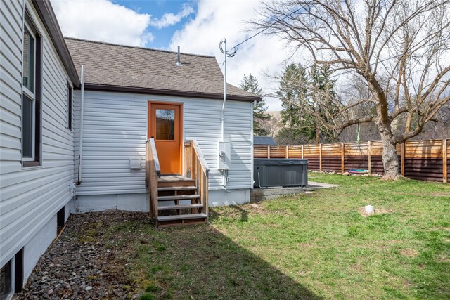 exterior space featuring a yard, a shingled roof, and fence