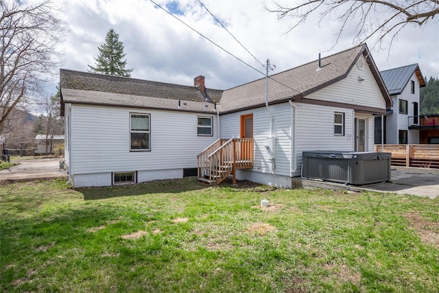 back of property featuring a hot tub, a yard, a chimney, fence, and central air condition unit