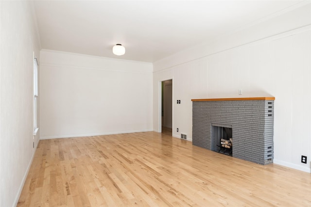 unfurnished living room with visible vents, baseboards, light wood-type flooring, and a brick fireplace