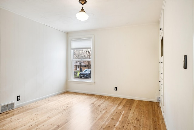spare room with light wood-type flooring, baseboards, and visible vents