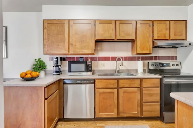 1895 E Broadway St, Missoula, MT 59802 - kitchen with under cabinet range hood, stainless steel appliances, light countertops, backsplash, and a sink