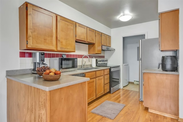 1895 E Broadway St, Missoula, MT 59802 - kitchen with a sink, light wood-style floors, light countertops, under cabinet range hood, and appliances with stainless steel finishes