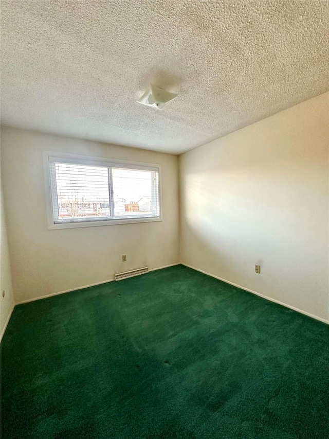 carpeted spare room with a textured ceiling and a baseboard heating unit