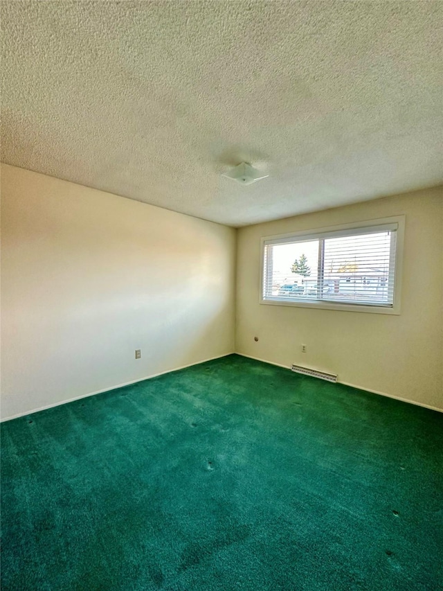 carpeted empty room featuring a textured ceiling and visible vents