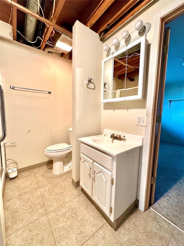 bathroom with tile patterned flooring, vanity, baseboards, and toilet