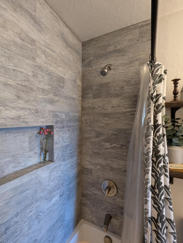 bathroom featuring shower / bath combo and a textured ceiling
