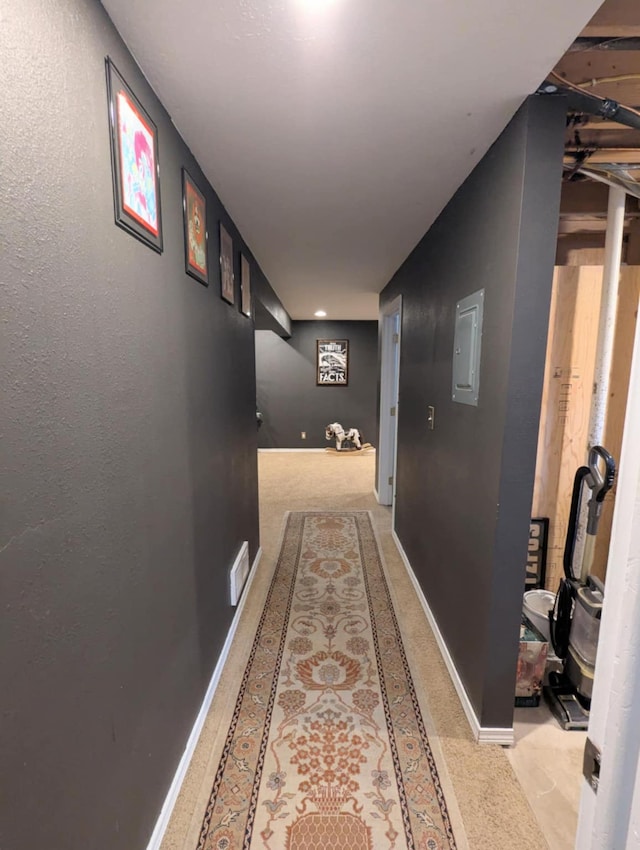 hallway with baseboards and electric panel
