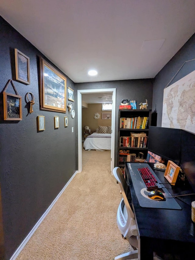 office area featuring a textured wall, baseboards, and carpet