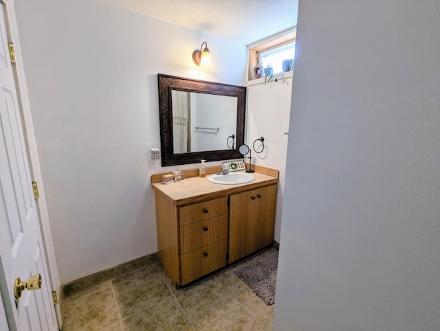 bathroom featuring tile patterned floors, baseboards, and vanity