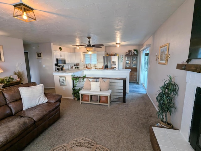 living area featuring ceiling fan, carpet flooring, baseboards, and a healthy amount of sunlight