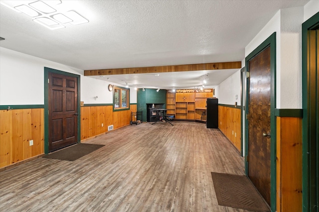 interior space featuring wooden walls, light wood-type flooring, and wainscoting