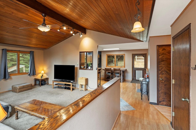 living area featuring wooden ceiling, baseboards, a ceiling fan, light wood-style floors, and vaulted ceiling with beams
