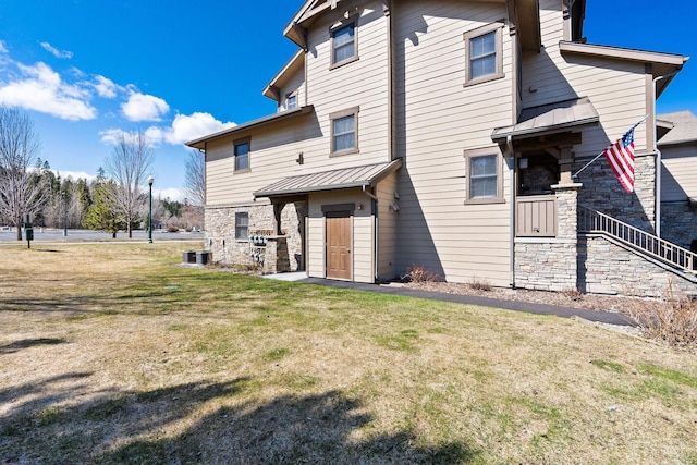 6104 Monterra Ave Unit A, Whitefish, MT 59937 - rear view of property featuring a standing seam roof, a metal roof, stone siding, and a lawn