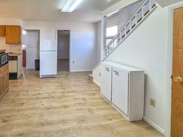 123 W Jefferson Ave, Chester, MT 59522 - kitchen featuring freestanding refrigerator, light wood-type flooring, black microwave, and decorative backsplash