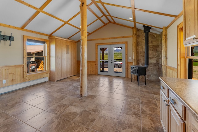 68 Bieler Ln, Sheridan, MT 59749 - unfurnished living room with vaulted ceiling, wainscoting, french doors, wood walls, and a wood stove