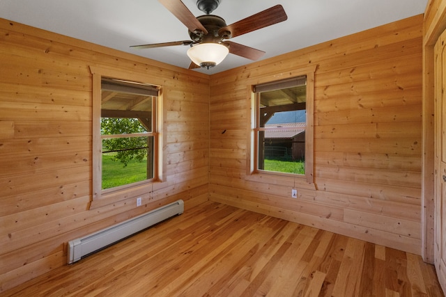 68 Bieler Ln, Sheridan, MT 59749 - empty room featuring a baseboard radiator, wooden walls, light wood-style floors, and a ceiling fan