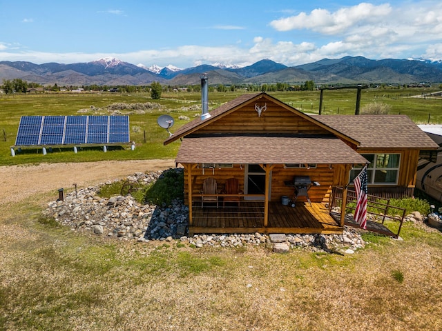 68 Bieler Ln, Sheridan, MT 59749 - rear view of property featuring a mountain view, solar panels, a shingled roof, and a view of rural / pastoral area