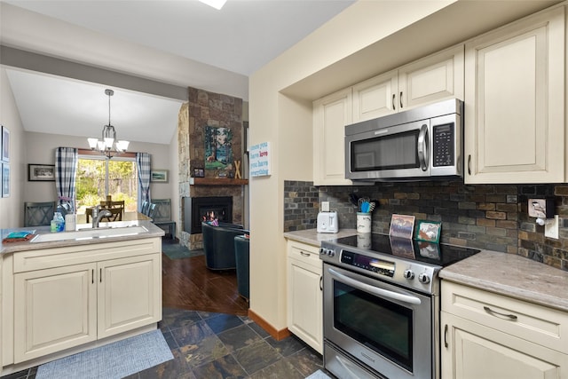 1750 E Lakeshore Dr Unit 203, Whitefish, MT 59937 - kitchen featuring stainless steel appliances, a chandelier, vaulted ceiling, tasteful backsplash, and open floor plan