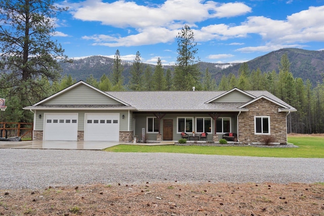 388 Cherry Creek Rd, Thompson Falls, MT 59873 - ranch-style home with stone siding, a mountain view, covered porch, concrete driveway, and an attached garage