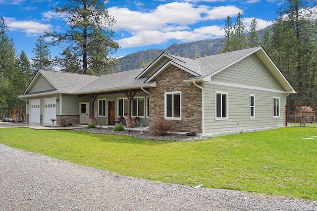 388 Cherry Creek Rd, Thompson Falls, MT 59873 - view of front facade with stone siding, a garage, a mountain view, a front lawn, and concrete driveway