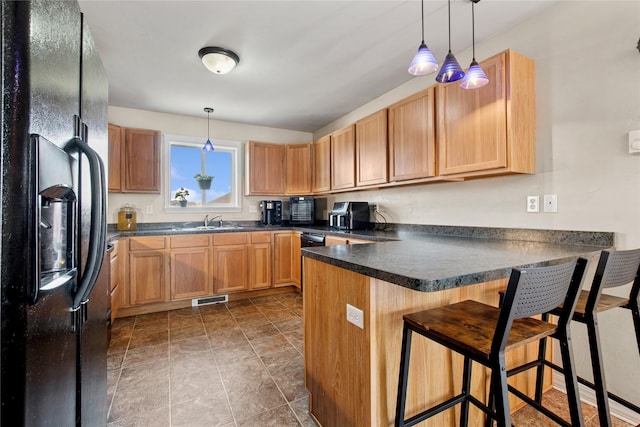 227 Jackson Peak Dr, Kalispell, MT 59901 - kitchen featuring a peninsula, dark countertops, black refrigerator with ice dispenser, visible vents, and a sink