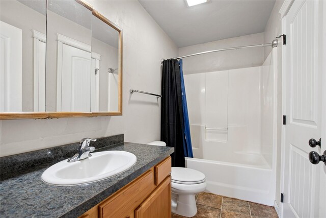 227 Jackson Peak Dr, Kalispell, MT 59901 - bathroom with shower / bath combo, toilet, stone finish floor, and vanity