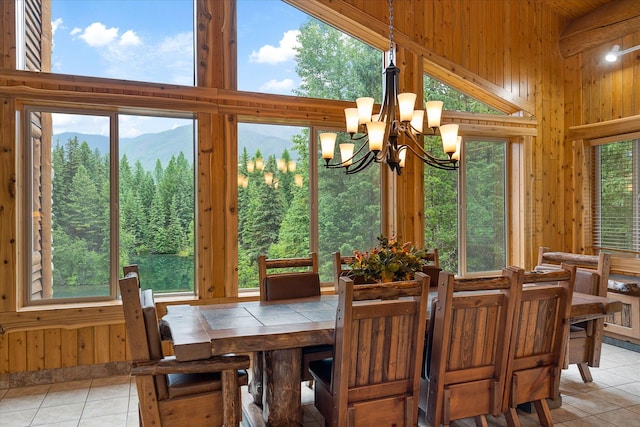 3700 Glen Lake Rd, Eureka, MT 59917 - dining space with light tile patterned floors, a high ceiling, a chandelier, and wooden walls