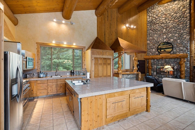 3700 Glen Lake Rd, Eureka, MT 59917 - kitchen featuring stainless steel appliances, light tile patterned flooring, a towering ceiling, a wooden ceiling with exposed beams, and an island with sink