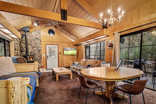 3700 Glen Lake Rd, Eureka, MT 59917 - dining room with a wood stove, healthy amount of natural light, a chandelier, wood walls, and carpet