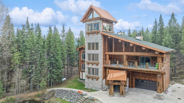 3700 Glen Lake Rd, Eureka, MT 59917 - view of front of house featuring stone siding, an attached garage, a balcony, driveway, and a chimney