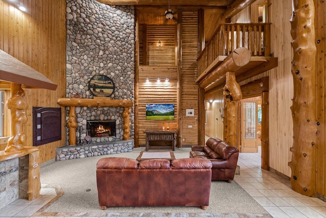 3700 Glen Lake Rd, Eureka, MT 59917 - living room featuring a stone fireplace, a towering ceiling, wood walls, and tile patterned flooring