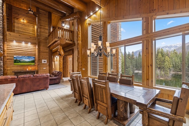 3700 Glen Lake Rd, Eureka, MT 59917 - dining room with light tile patterned flooring, a high ceiling, wooden walls, a chandelier, and a view of trees