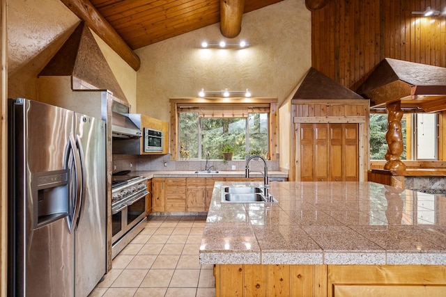 3700 Glen Lake Rd, Eureka, MT 59917 - kitchen with appliances with stainless steel finishes, tile counters, light tile patterned floors, a wood ceiling with exposed beams, and decorative backsplash