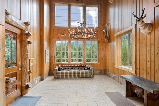 3700 Glen Lake Rd, Eureka, MT 59917 - mudroom featuring wooden walls, a chandelier, a high ceiling, and light tile patterned flooring