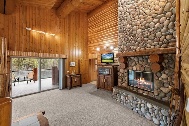 3700 Glen Lake Rd, Eureka, MT 59917 - living area with a towering ceiling, a wood ceiling with exposed beams, light carpet, a fireplace, and wood walls